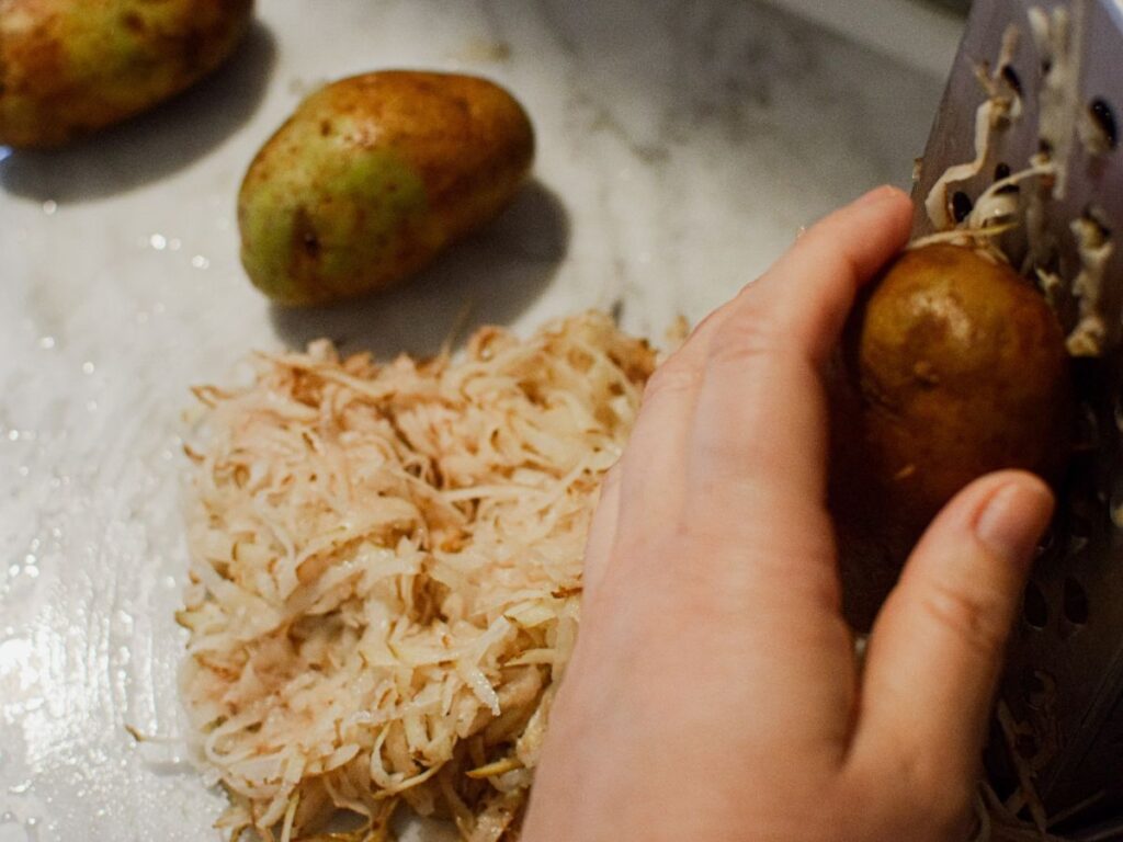 woman shredding potatoes